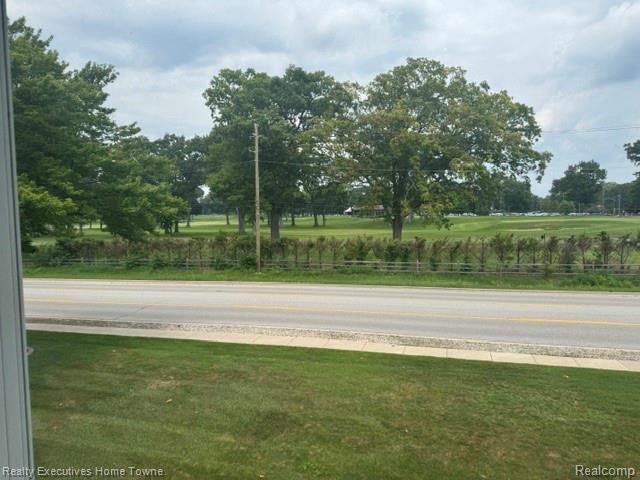 1467 Krafft Road, Unit 8 Port Huron, MI 48060 - Photo 21 of 28 Expansive green space featuring mature trees and a manicured lawn, bordered by a hedge row and paved road