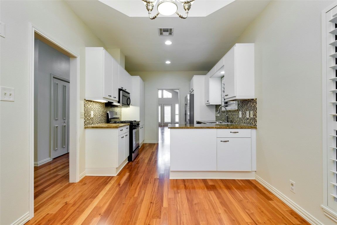 3509 Fawn Trail Austin, TX 78746 - Photo 11 of 30 a kitchen with white cabinets appliances and wooden floor