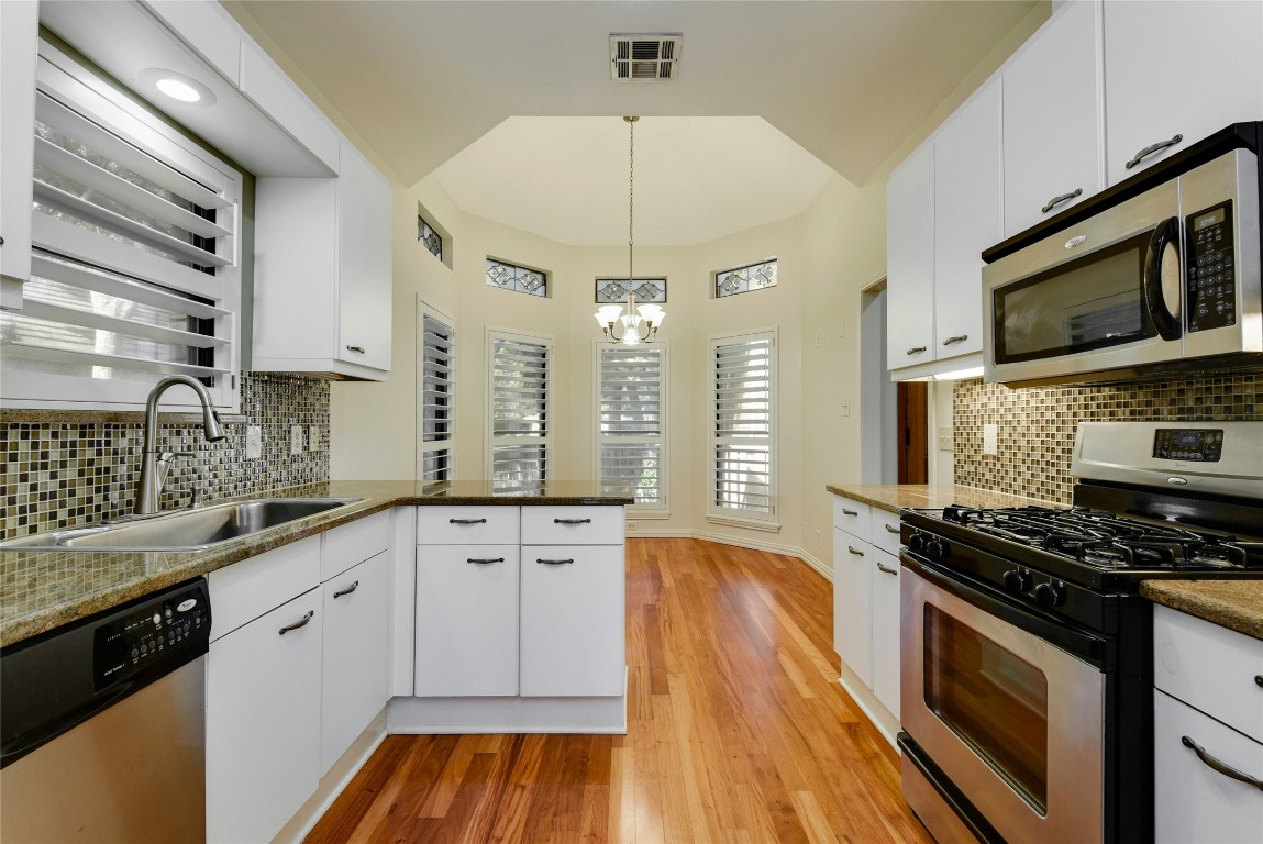 3509 Fawn Trail Austin, TX 78746 - Photo 14 of 30 a kitchen with stainless steel appliances a stove sink microwave and cabinets