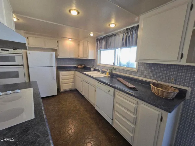 a kitchen with a sink stove and refrigerator