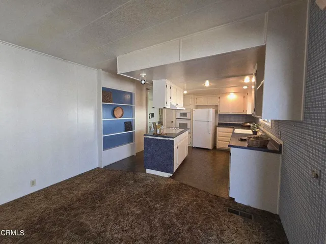 a kitchen with stainless steel appliances granite countertop a refrigerator a sink dishwasher a stove with wooden cabinets