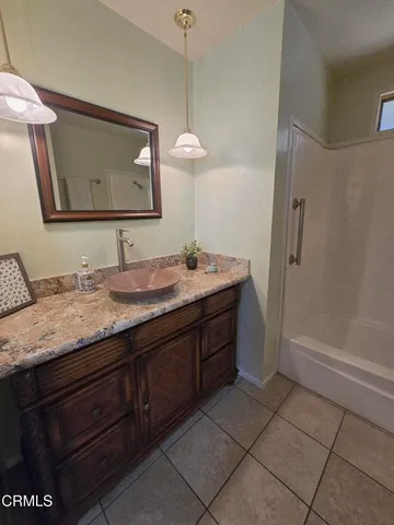 a bathroom with a granite countertop sink a mirror and a vanity