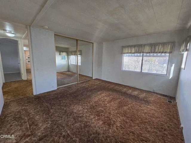 an empty room with windows and closet