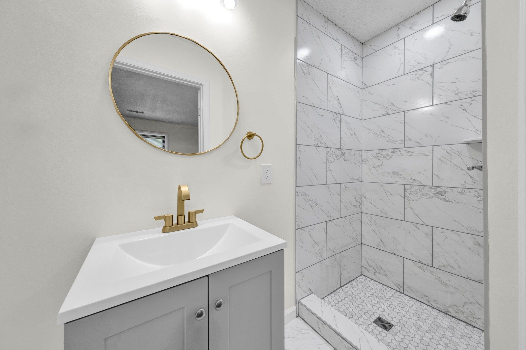 6681 Raleigh Millington Road Millington, TN 38053 - Photo 22 of 28 Bathroom with marble finish floors, vanity, and a tile shower