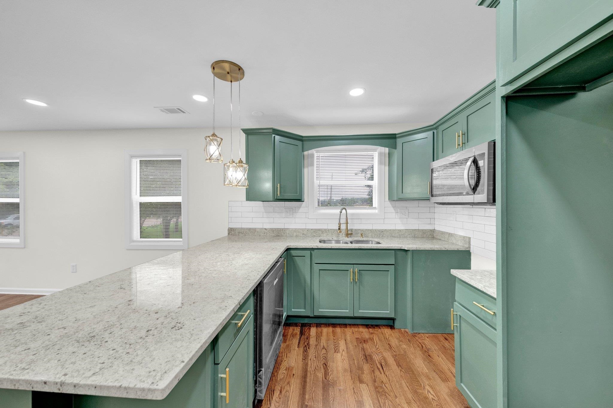 6681 Raleigh Millington Road Millington, TN 38053 - Photo 10 of 28 Kitchen with stainless steel appliances, green cabinets, a peninsula, tasteful backsplash, and light wood finished floors