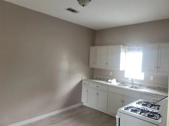a kitchen with a sink stove and cabinets