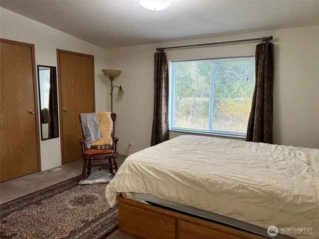 a bedroom with a bed chair and a window