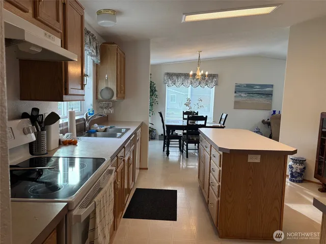 a kitchen with a dining table chairs sink and granite counter tops