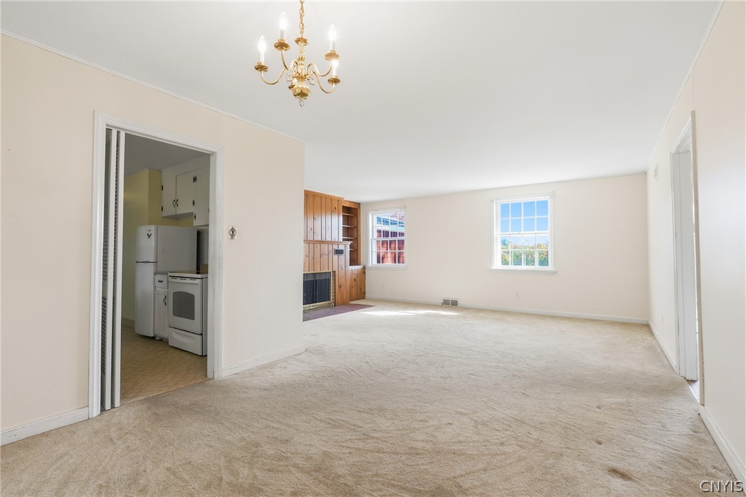 7779 Bell Road North Rome, NY 13440 - Photo 12 of 38 A classic fireplace accentuates this open living area with soft carpeting and natural light.