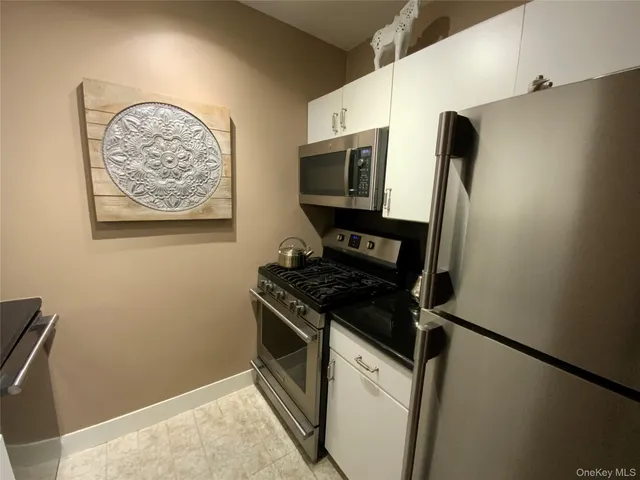 a kitchen with stainless steel appliances a refrigerator and a stove top oven