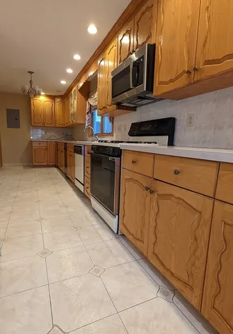 a kitchen with stainless steel appliances granite countertop a stove a sink and a microwave