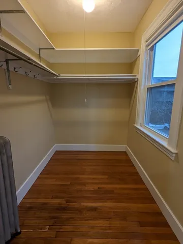 a view of a room with wooden floors and brick walls
