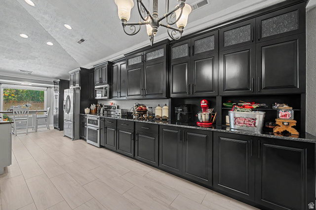 3034 Swiss Drive Santa Clara, UT 84765 - Photo 18 of 59 Kitchen featuring extensive black cabinetry, dark speckled countertops, and light wood-finish flooring