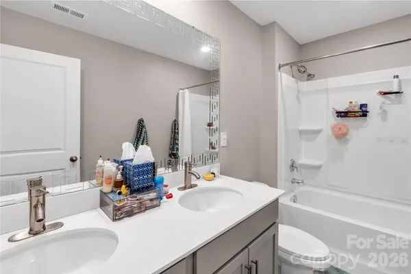 a bathroom with a sink double vanity granite tub shower and a mirror