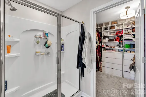 a view of walk in closet with clothes and shoes