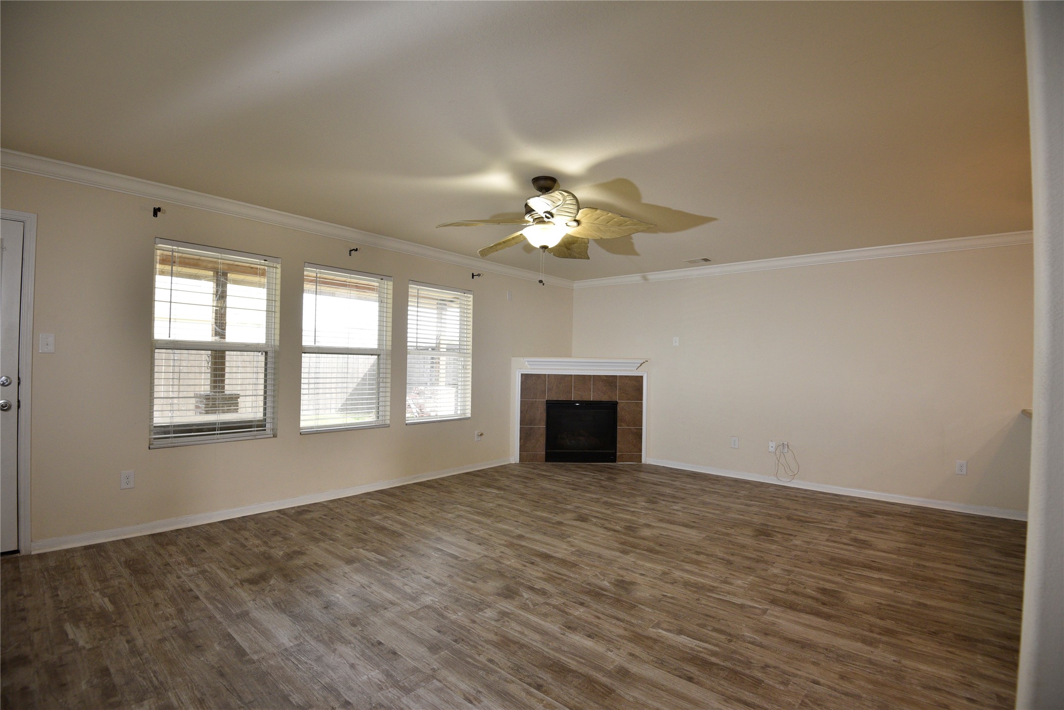 9997 Hyacinth Way Conroe, TX 77385 - Photo 14 of 45 a view of an empty room with chandelier fan and fire place