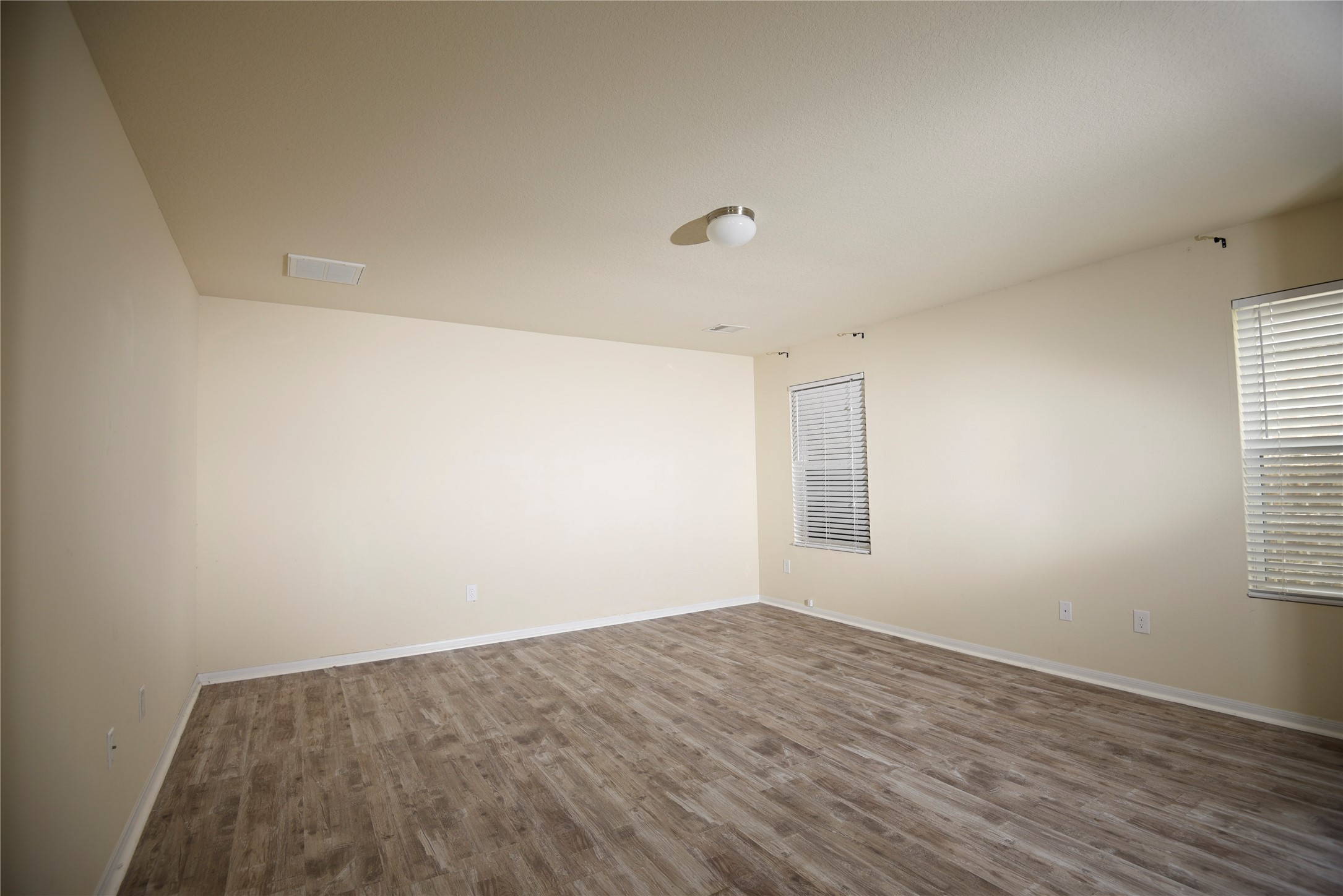 9997 Hyacinth Way Conroe, TX 77385 - Photo 15 of 45 an empty room with wooden floor and windows