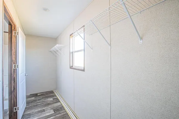 a view of hallway with window and wooden floor