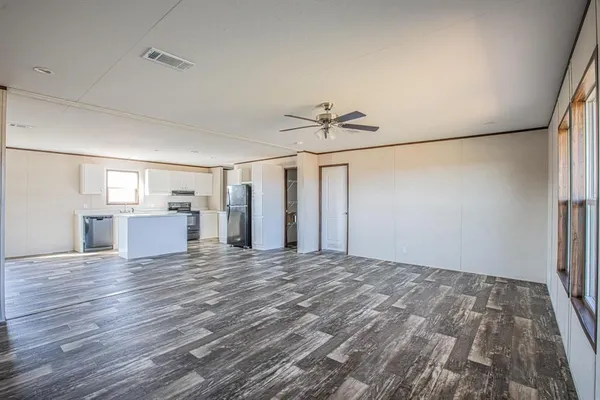 a view of empty room with wooden floor and window