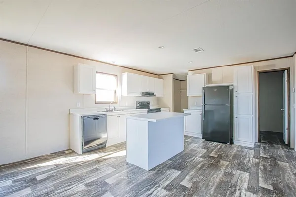 a room with kitchen island and stainless steel appliances