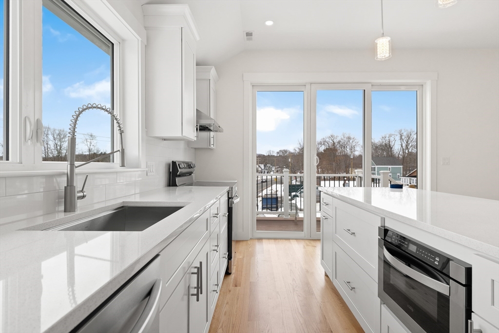 2 Old County Road, Unit 10 Salisbury, MA 01952 - Photo 5 of 27 a kitchen with a sink a stove cabinets and a wooden floor