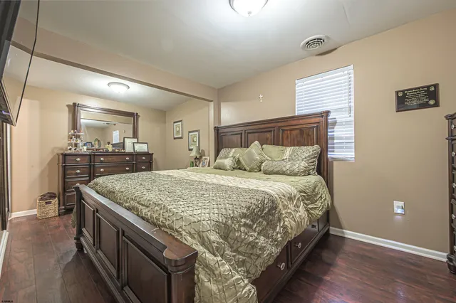 a spacious bedroom with a bed and a dresser