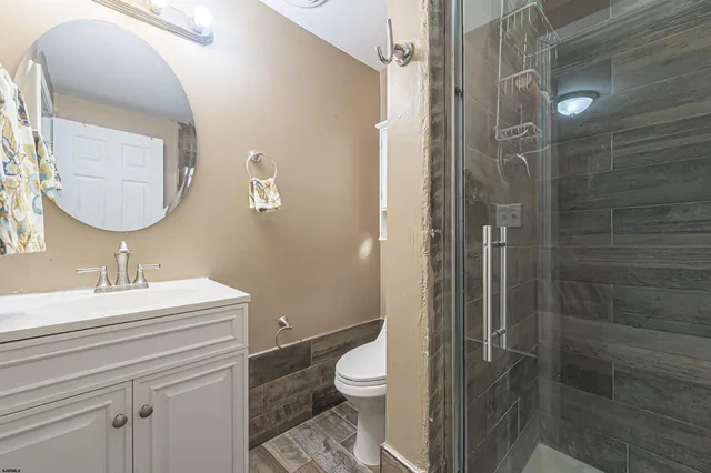 a bathroom with a sink a toilet and shower