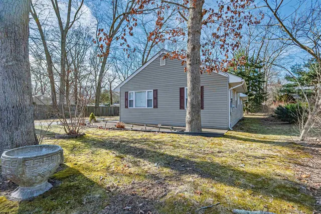 a backyard of a house with fountain table and chairs under an umbrella