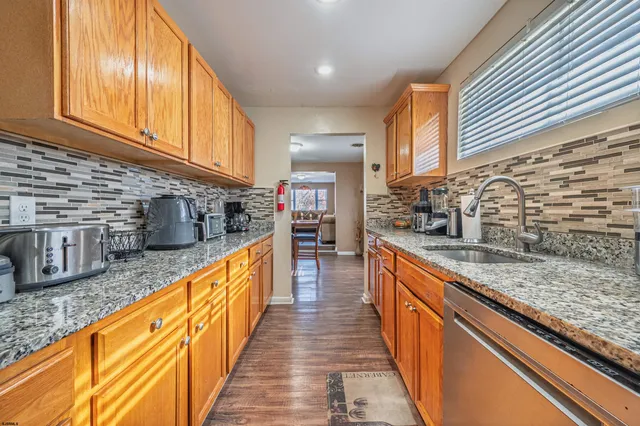 a large kitchen with stainless steel appliances granite countertop a sink and cabinets