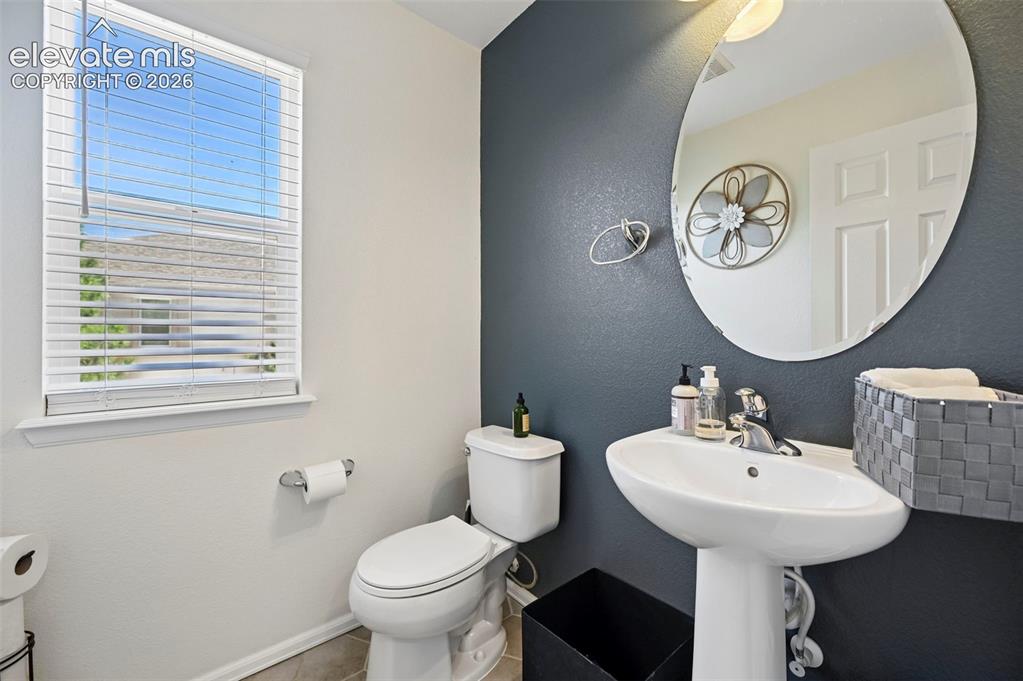 10643 Pictured Rocks Drive Peyton, CO 80831 - Photo 27 of 37 a bathroom with a toilet a sink and a mirror