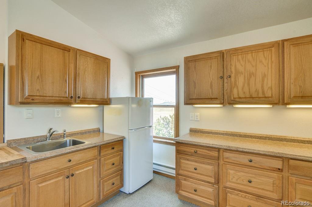 681 Forge Road Hartsel, CO 80449 - Photo 27 of 41 a kitchen with granite countertop cabinets stainless steel appliances a sink and wooden floor