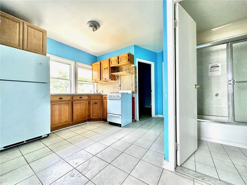457 Van Sicklen Street Brooklyn, NY 11223 - Photo 3 of 8 a kitchen with a refrigerator and a sink