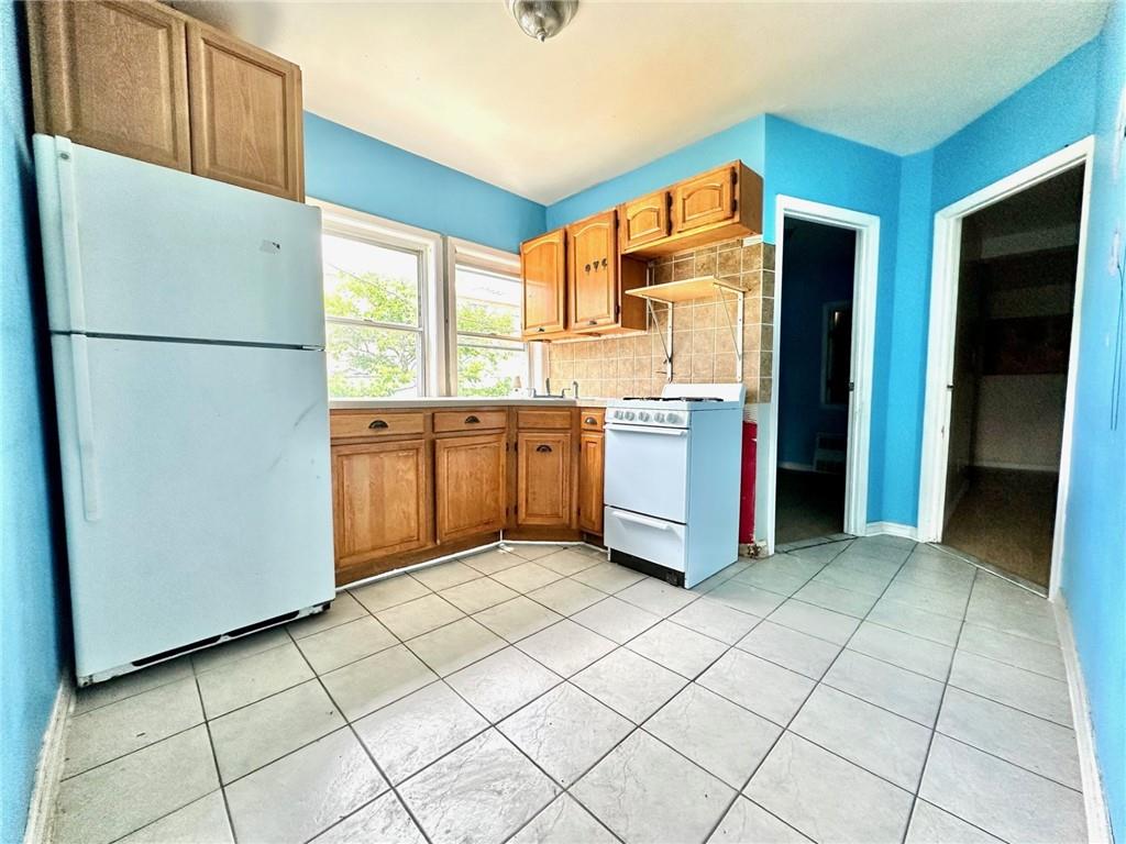 457 Van Sicklen Street Brooklyn, NY 11223 - Photo 4 of 8 a kitchen with stainless steel appliances granite countertop a refrigerator and a stove