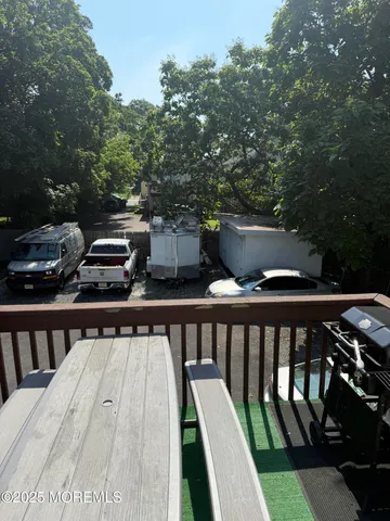 a view of a balcony with wooden floor and outdoor seating