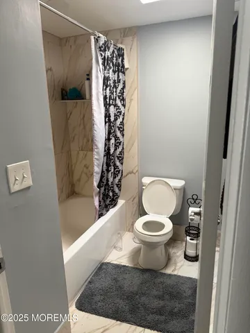 a bathroom with a toilet and a shower