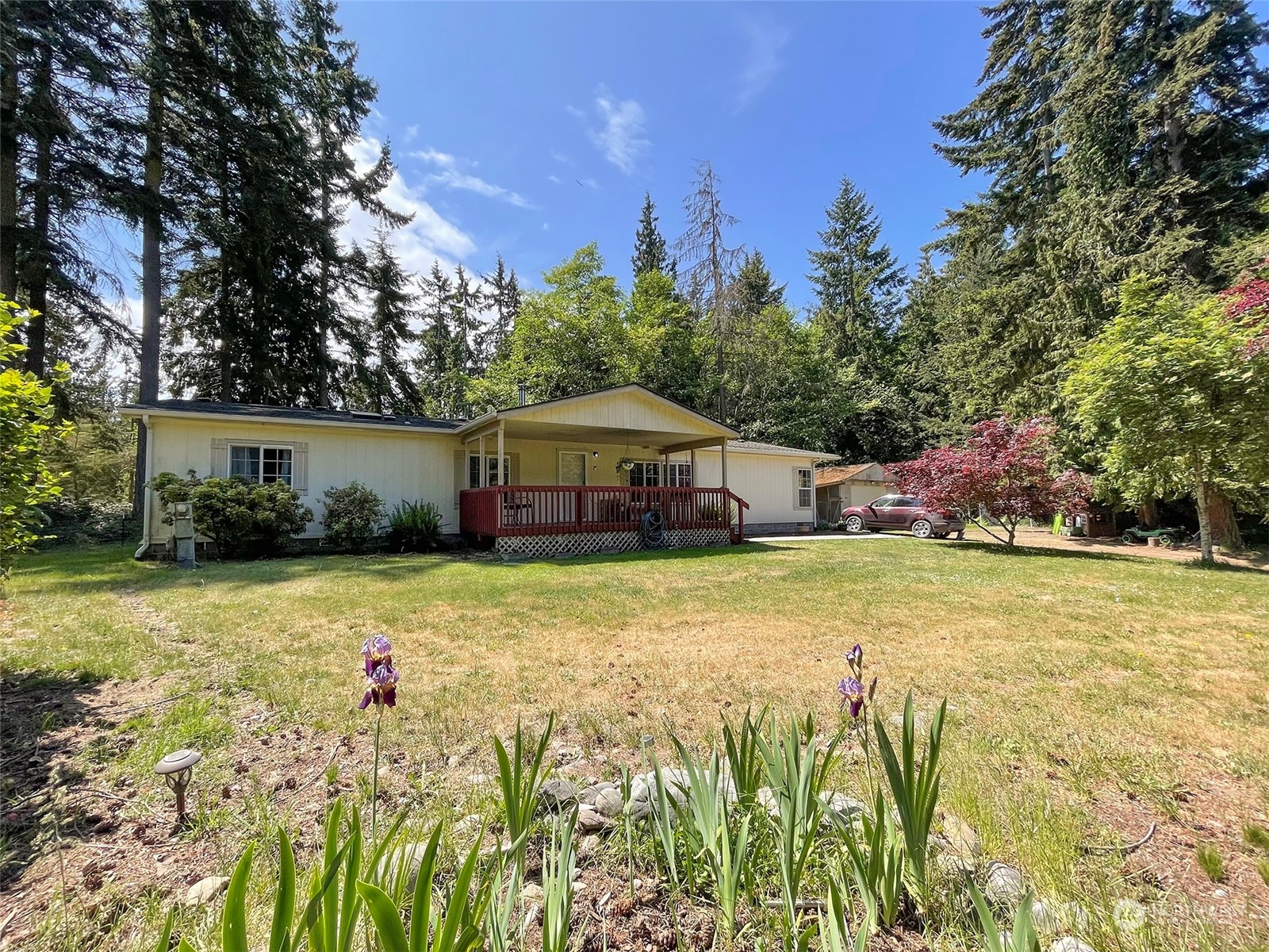 a front view of house with yard and trees in the background