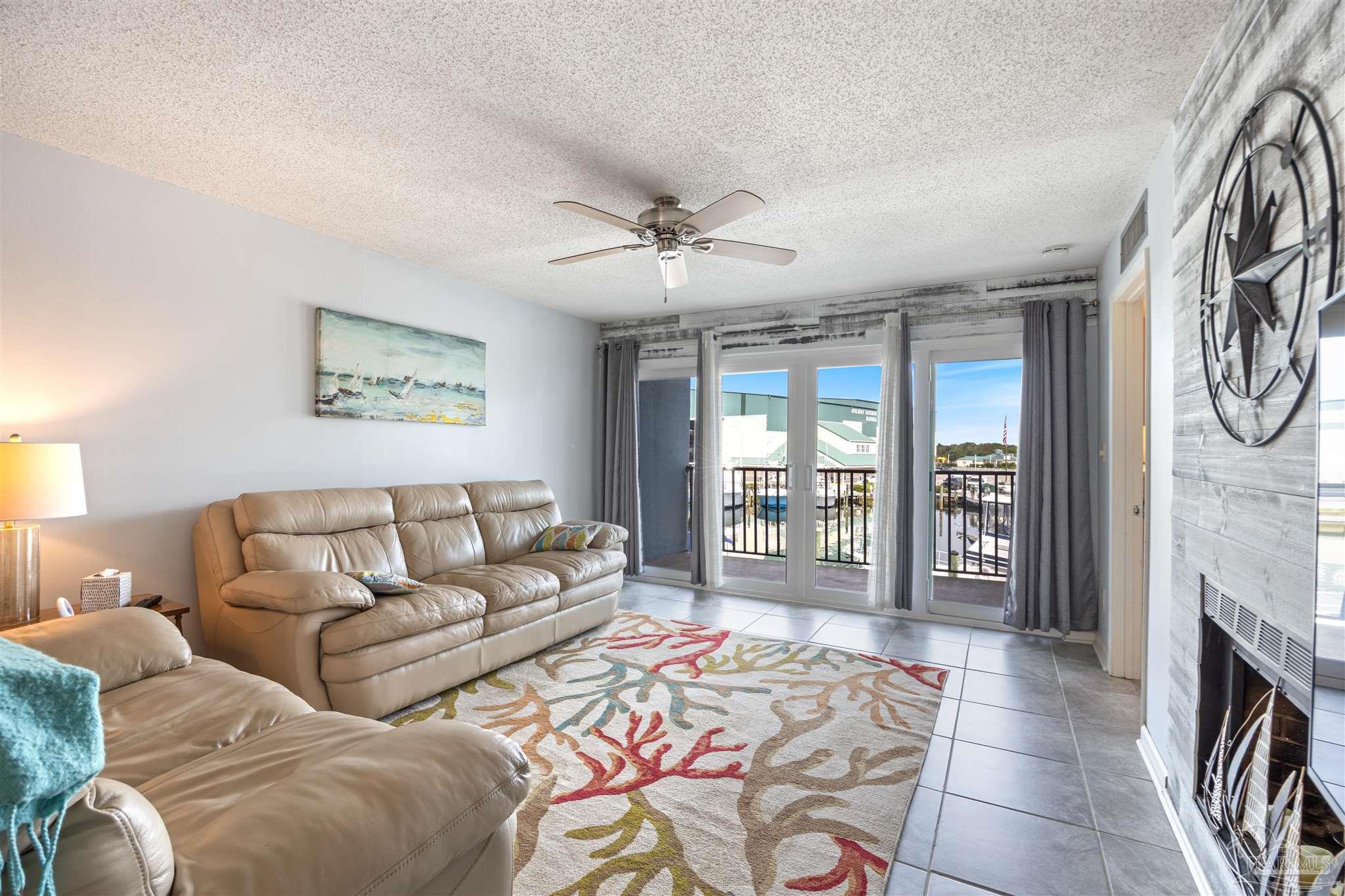 14100 River Road, Unit 228B Pensacola, FL 32507 - Photo 12 of 41 a living room with furniture a fireplace and a chandelier