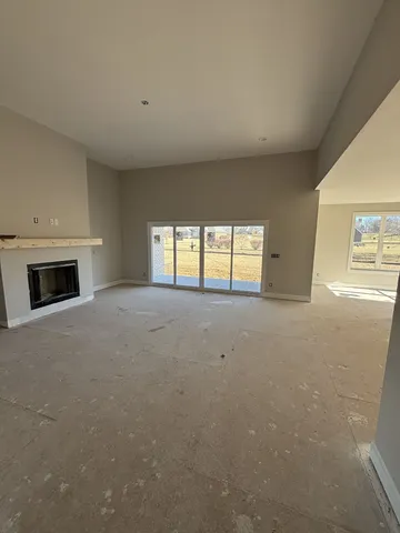 a view of an empty room with a fireplace and a window