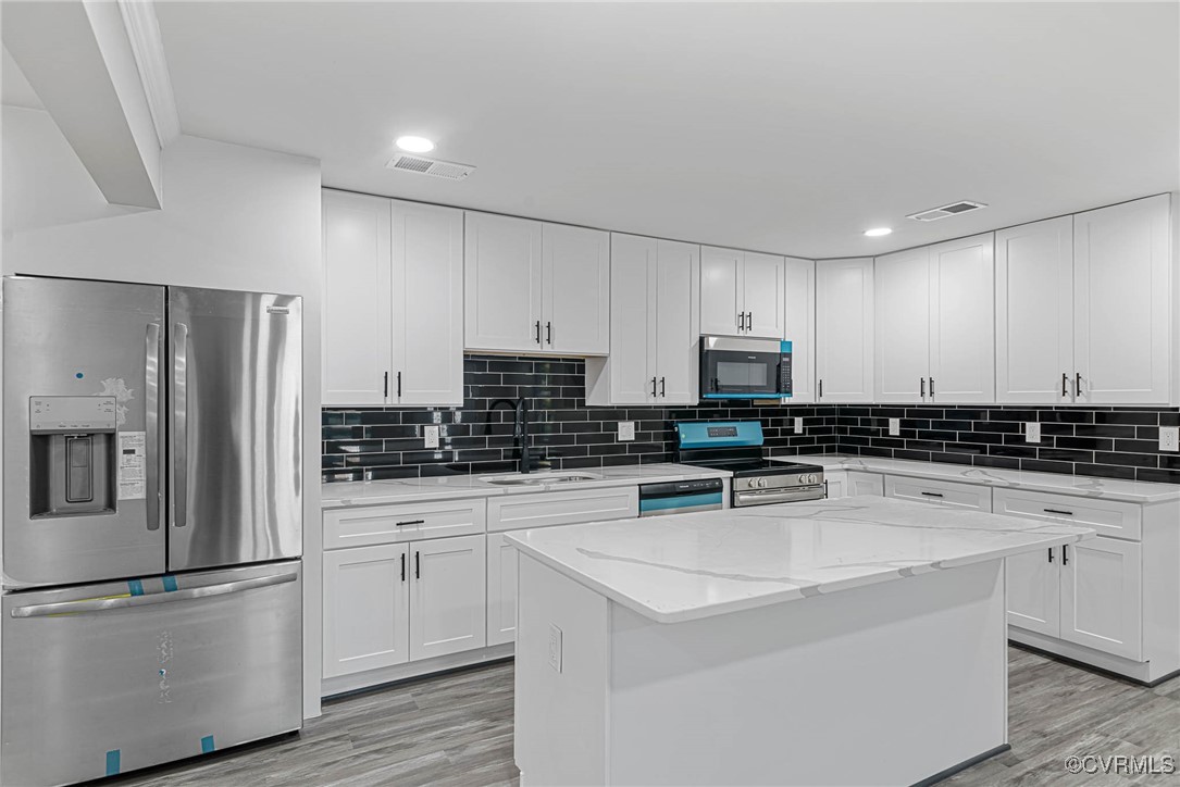 15412 Moores Mill Road Ruther Glen, VA 22546 - Photo 11 of 31 a kitchen with stainless steel appliances a stove a sink a refrigerator and white cabinets