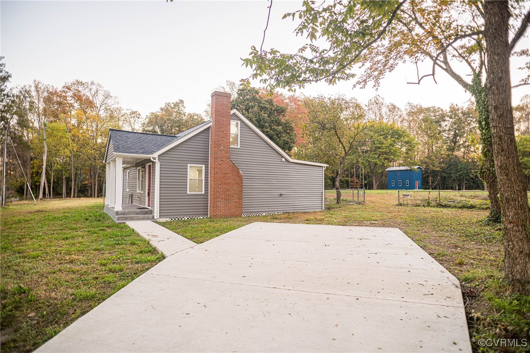 15412 Moores Mill Road Ruther Glen, VA 22546 - Photo 3 of 31 a backyard of a house with large trees and wooden fence