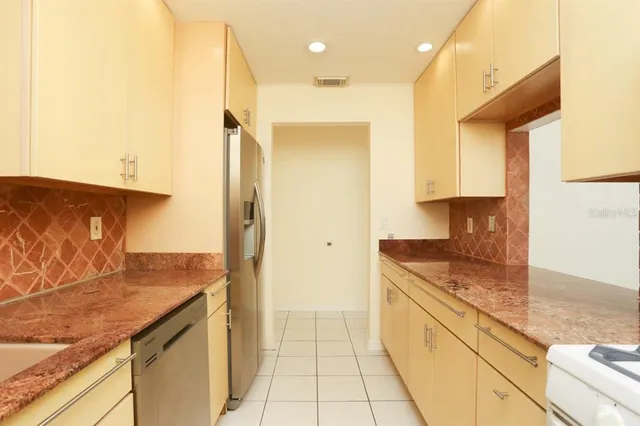 a kitchen with stainless steel appliances granite countertop a refrigerator and a sink