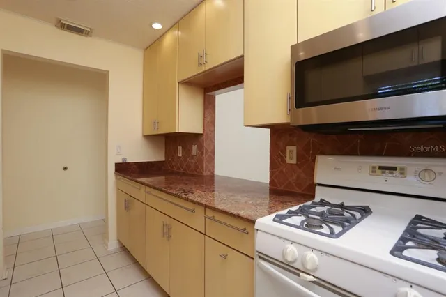 a view of a livingroom with a chandelier fan and windows