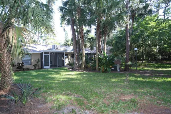 a backyard of a house with plants and large trees