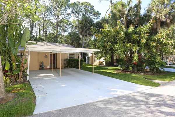 a view of a house with a yard and large tree