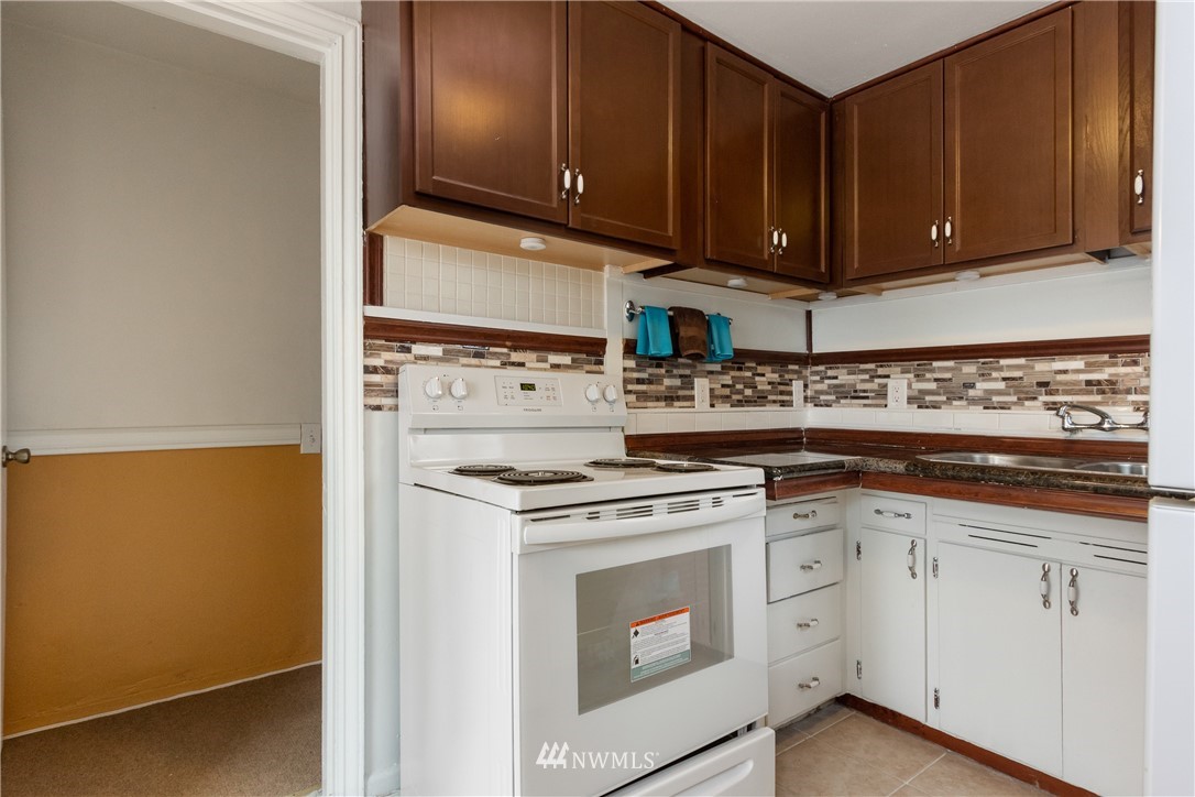 10651 Rustic Road South Seattle, WA 98178 - Photo 9 of 34 a kitchen with white cabinets and white appliances