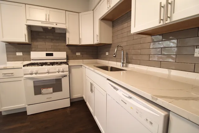 a kitchen with white cabinets and white appliances