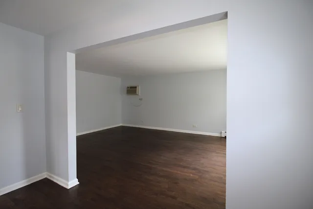 a view of an empty room with wooden floor