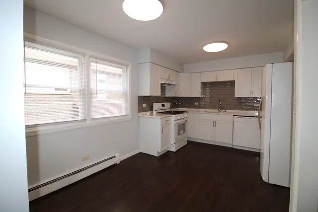 a kitchen with granite countertop white cabinets and white appliances