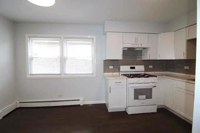 a kitchen with a refrigerator sink and cabinets
