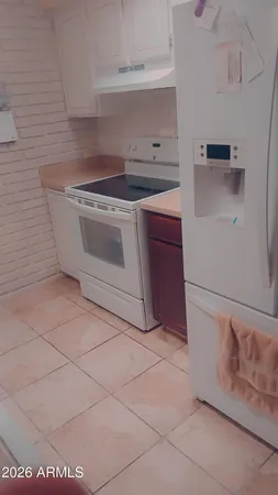 a white stove top oven sitting inside of a kitchen